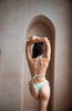 girl wearing a mint cheeky bikini bottom set.