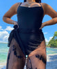 girl wearing a seamless black one piece swimsuit with thin straps and scoop neckline.