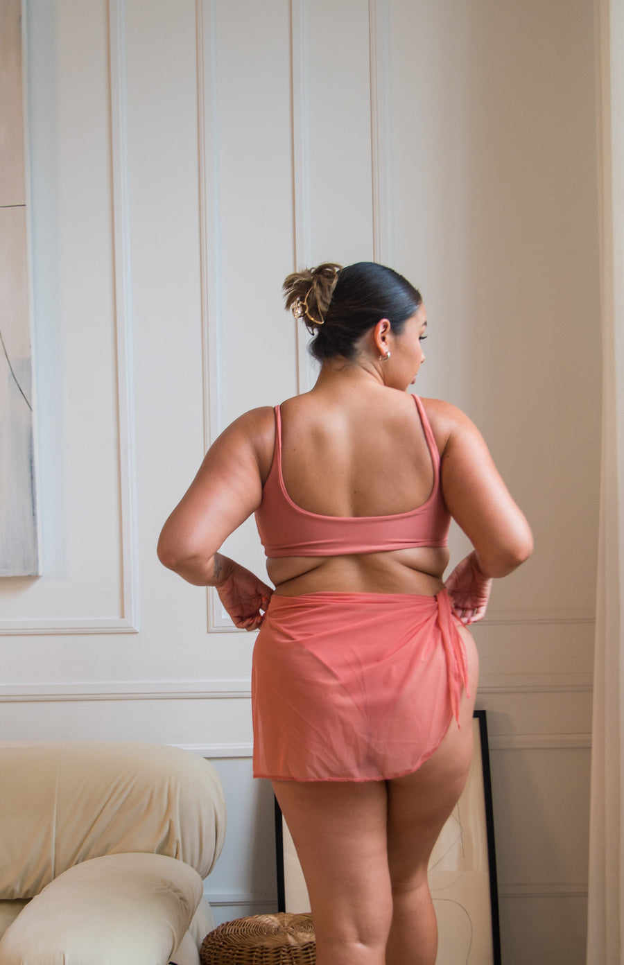 girl wearing a coral / pink bikini with a mesh sarong