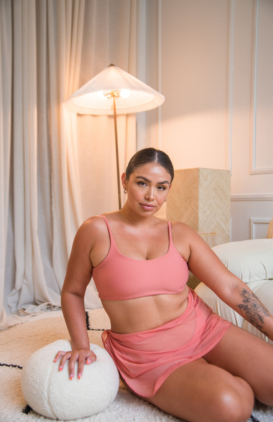 Girl wearing coral / pink scoop neck bikini top with a matching mesh sarong