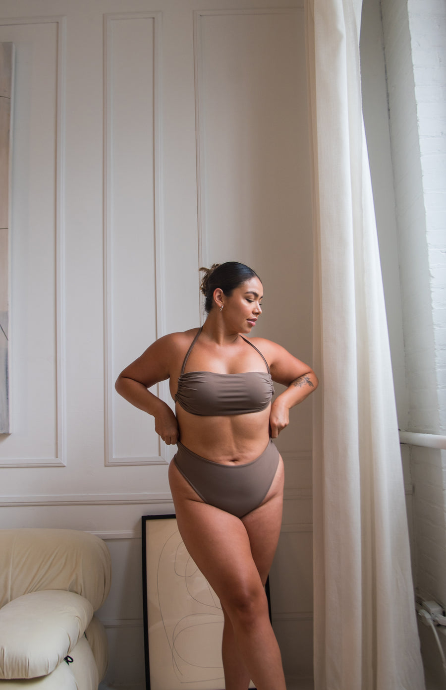 girl wearing a taupe tube top style bikini top with high rise bottoms