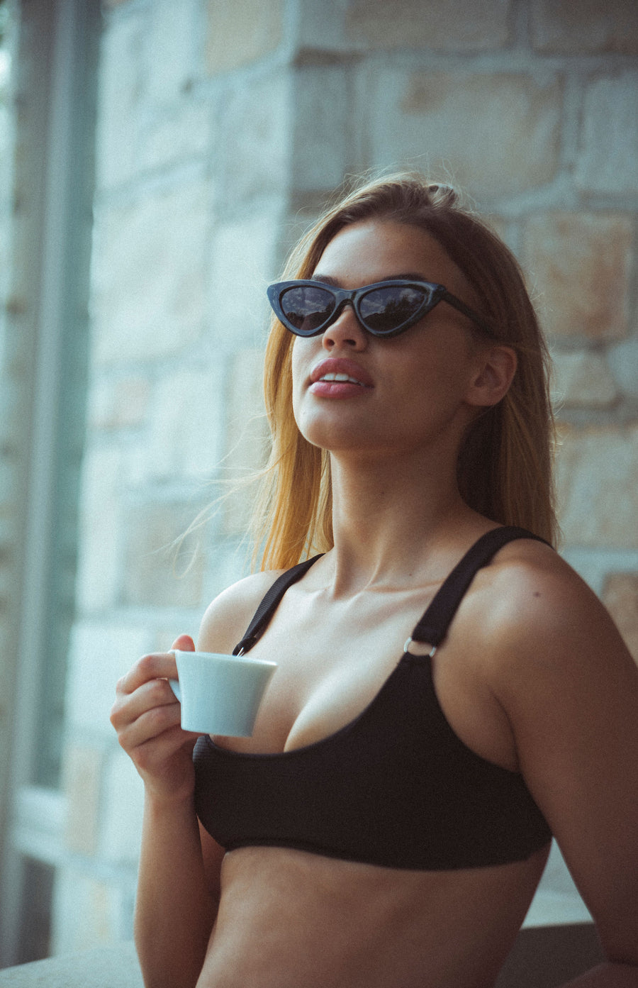 girl wearing black ribbed bikini scoop neck top with two silver round rings on each strap in the front. Adjustable straps.